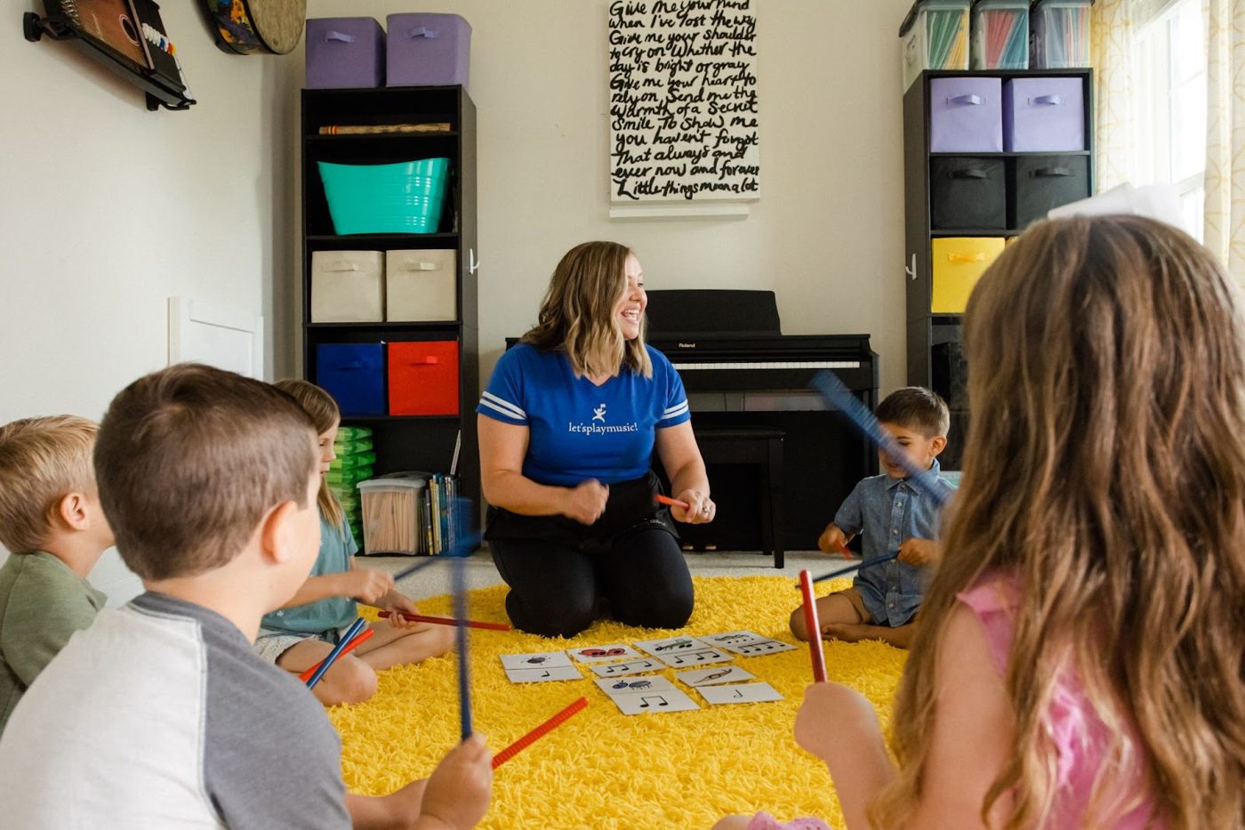 Children playing rhythm sticks in class