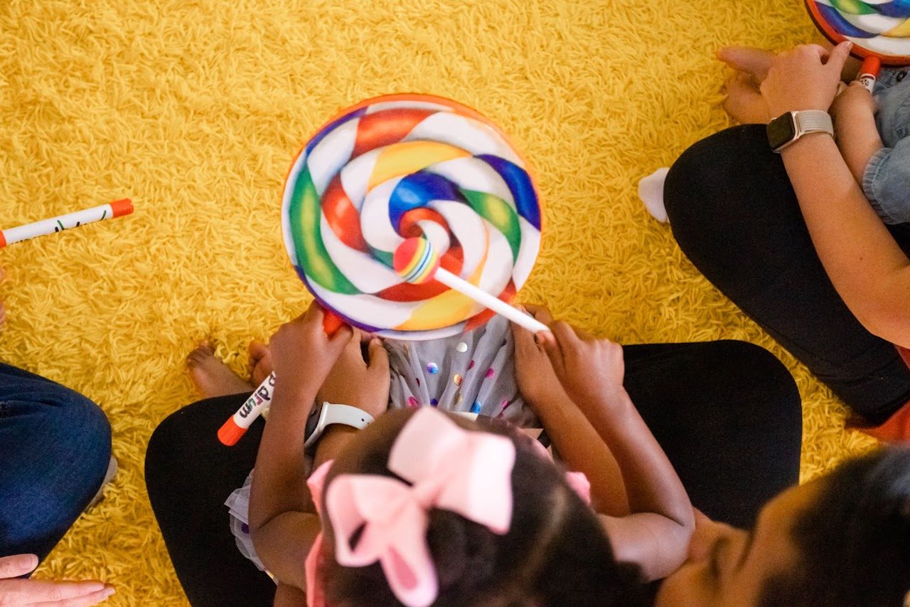 A child playing a lollipop drum in a Sound Beginnings class