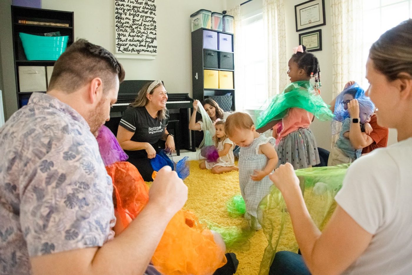 Parents and toddlers playing with scarves